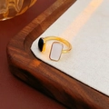 Dettaglio anello geometrico di lusso con smalto bianco e nero e base dorata - Nero e Bianco