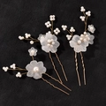 Set di tre forcine dorate con fiori bianchi opachi e perle su sfondo nero materico - Oro Set di 3