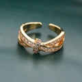 Detalle macro de un anillo cruzado dorado ajustable con pavé de circonitas cúbicas - Dorado