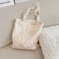 Detail der Blumenstickerei und Lochmuster auf dem cremeweißen Canvas-Shopper - Umhängetasche (Ohne Zubehör)