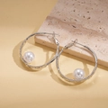 Detail van zilveren oorringen met witte parels en een verfijnde gehamerde afwerking - Zilver Gehamerd Witte Parelstijl / Zilver