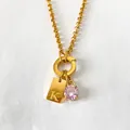 Gold stainless steel necklace with 'K' initial pendant and sparkling pink crystal. - Letter K