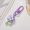 Close-up of purple tulip flower keychain with white pistils and green leaves charm - Purple Flower Shape