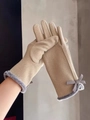 Detail of beige fleece gloves with grey fur trim and bow decoration for winter warmth - Khaki