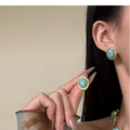 Primer plano de pendientes vintage de oro con piedras turquesas ovales en modelo - Pendientes de botón de piedra azul (pin de plata)