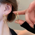 Detail view of gold hoop earrings with star patterns and a star pendant on ear - Gold Star Pendant Style (105#)