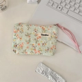 Close-up of floral mint green canvas pouch with pink drawstring on a white desk - Mint Green Base Floral / Orange Floral
