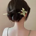 Detalle de horquilla vintage con racimos de uva de imitación jade en un moño elegante - Horquilla de uva verde