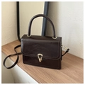 Détail d'un sac à main vintage en cuir PU marron foncé avec fermoir doré sur bois - Marron
