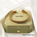 Detail of golden woven twisted bangle with square ends on green jewelry box - Gold 2