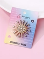 Elegant starburst brooch in gold alloy with shimmering crystals on display card - Gold Starburst Rhinestone