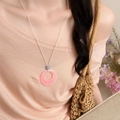 Close-up view of a sweet pink marble resin circle pendant necklace on a light cord - Round / Pink