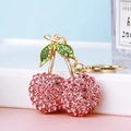 Pink rhinestone cherry keychain in gold alloy with green leaf detail and metal ring - Pink