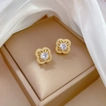 Detailed view of gold clover earrings with white zircons on a luxury silk background - Lucky Clover Stud Earrings (D434)