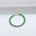 Detail shot of a gold tennis bracelet featuring rectangular green zircon stones in a row - Green