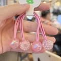 Close-up of four pink handmade elastic hair ties with glitter resin ball charms - 2-Piece Set / Pink
