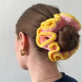 Pink and yellow crochet scrunchie worn on a bun hair style for a trendy handmade look - Light Pink with Yellow Edge