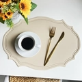 Oval beige faux leather placemat with dotted edge texture on white table background - Beige Faux Leather Vintage Oval