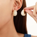 Detailed shot of vintage teardrop earrings with cream resin inlay and gold metal frame - White Enamel Waterdrop