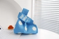 Close-up of blue polka dot knit tote bag featuring 'Stay HUNGRY' text on handle - Blue Background With White Dots