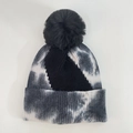 Close-up of tie-dye knit beanie with black fluffy faux fur pompom and ribbed cuff - Black