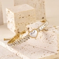 Détail d'un bracelet doré orné de zircons baguette et d'un cœur en nacre blanche - Cœur/Nacre Blanche