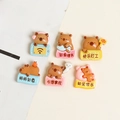 Flat lay of six cute resin capybara DIY charms with diverse colors and lucky slogans - Capybara Word Plate