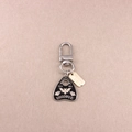 Macro shot of silver Ouija planchette pendant keychain with engraved gold Harmony tag - Letter Planchette - White Text