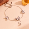 Detailed view of silver butterfly charms on a stainless steel chain with bead tassel - Silver Butterfly Bracelet