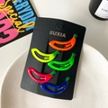 Set of five vibrant banana-shaped hair clips in bright fluorescent colors on black card - Yellow-Green Bananas