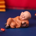 Cute nodding little monk figurine in orange robe lying with prayer beads for car dashboard - 1034-22 Lying Posture with Pillow Book