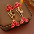 Macro-opname van rood-gouden visgraat oorbellen met hartvormige 'me!' details - S925 Zilveren Pin Visgraat Oorbellen / Goud met Rood