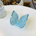 Detailed view of blue butterfly hair claw clip with acetate marble texture on white table - Approx 8.5cm / Light Blue