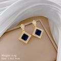 Macro shot of gold square earrings with blue gemstones and white zircon halo detail - Blue Stud Earrings (G208)