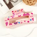 Close-up of pink heart-print hair claw clip with HAPPY DAY lettering and bow patterns - 8.5cm Heart Print - Style J Pink