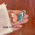 Detailed size view of a colorful butterfly enamel brooch with gold metal frame - Pink and Blue Butterfly Pair