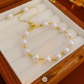 Detail of French pearl bracelet with gold beads on white velvet jewelry box lining - Gold Style