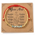 Bracelet tressé en cordon rouge avec perles dorées et œil porte-bonheur bleu sur carte - Style perles dorées + Carte Beautiful