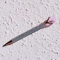 Detailed close-up of a rose gold pen featuring iridescent rhinestones and a purple crystal ball - Light Amethyst