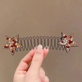 Detail of star-shaped hair comb with colorful rhinestones on a wavy black metal base - Champagne Star Spring Comb