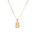 Macro shot of gold-plated letter S pendant with textured metal surface detail - Letter S