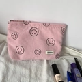 Pink corduroy makeup bag detail with minimalist smiley face and brand woven label - Pink Smiley Face Storage Bag