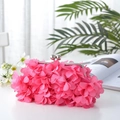 Close-up of a pink floral evening clutch bag featuring 3D petals and a silver metal clasp - Rose Red