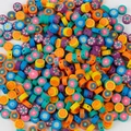 Nahaufnahme bunter Polymerton-Abstandshalter mit Blumenmustern für DIY-Schmuckherstellung - Blumenmuster