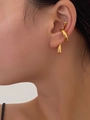 Primer plano del ear cuff dorado fluido y orgánico usado en el cartílago de la oreja - Dorado
