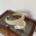 Detailopname van een beige gewatteerde geruite haarband op een sieradendoos - Khaki