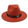 Close-up of rust red felt fedora with leather strap and silver bull head emblem - Caramel color