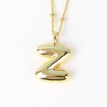 Close-up of golden 3D bubble letter Z pendant with polished metallic finish on white background - Letter Z