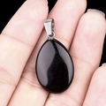 Polished black agate teardrop pendant with silver metal bail held by hand - Obsidian (1pc)