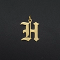 Macro shot of gold Gothic letter H pendant with a polished finish for DIY jewelry - Letter H